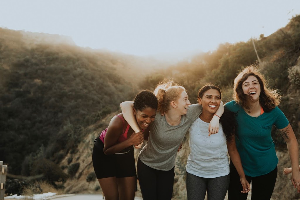 4 women hiking and laughing