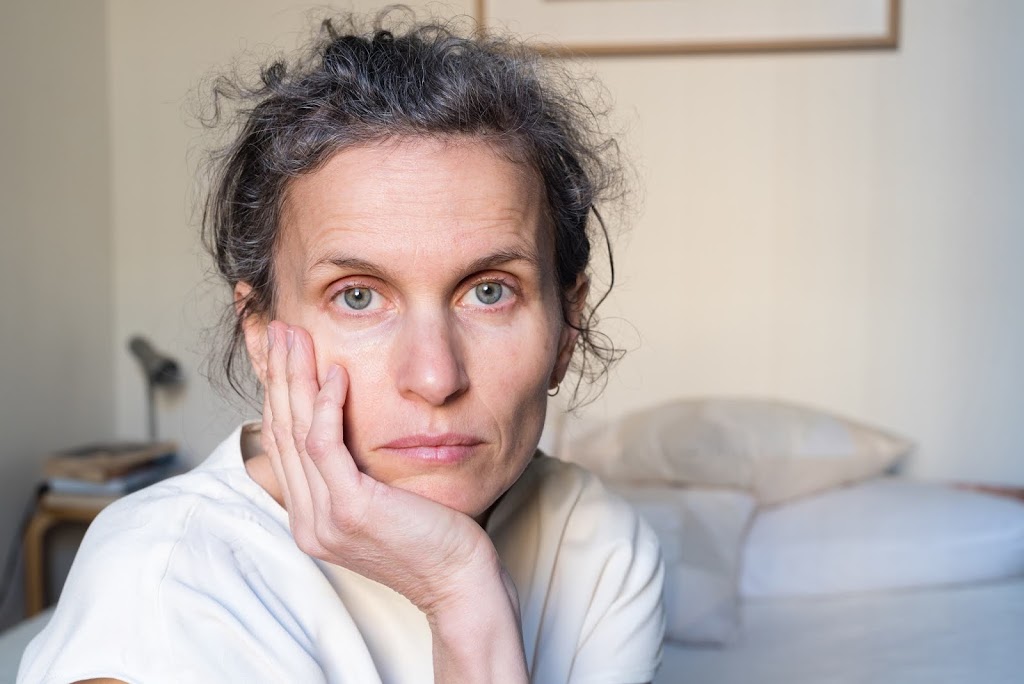 despondent middle aged woman in bedroom