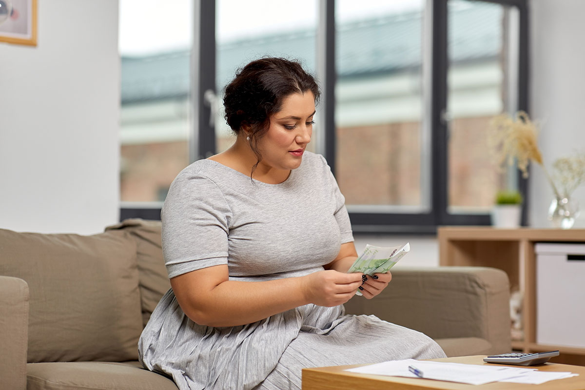 woman counting money on couch